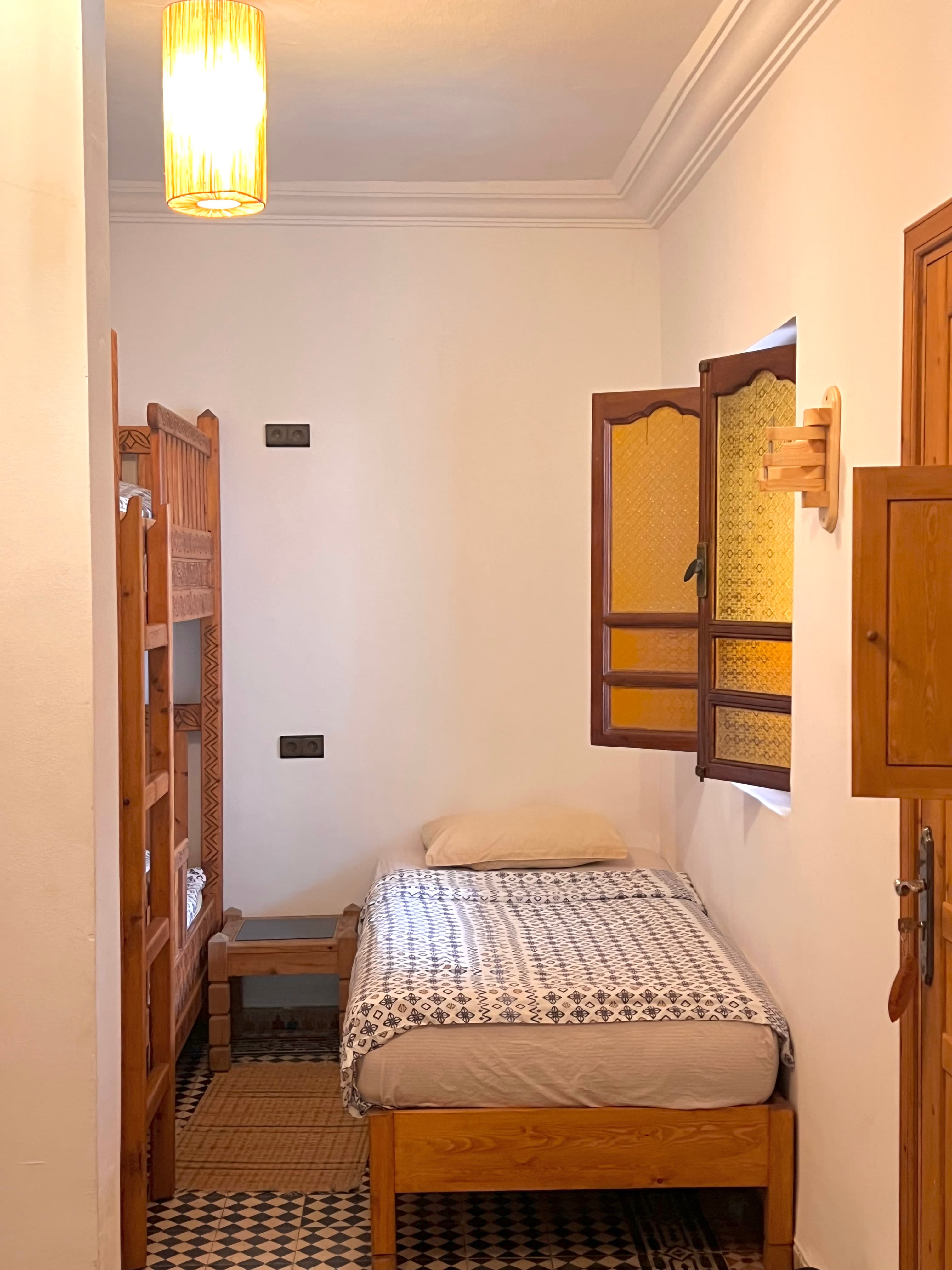 Spacious sharing room layout with comfortable mattresses and Moroccan rugs